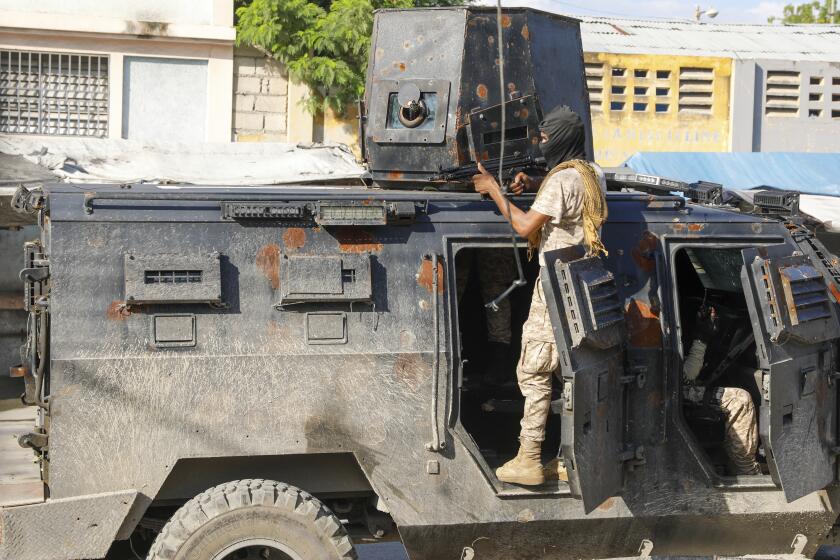 La policía se cobija durante una operación antipandillas en Puerto Príncipe, Haití, el viernes 1 de marzo de 2024. (AP Foto/Odelyn Joseph)