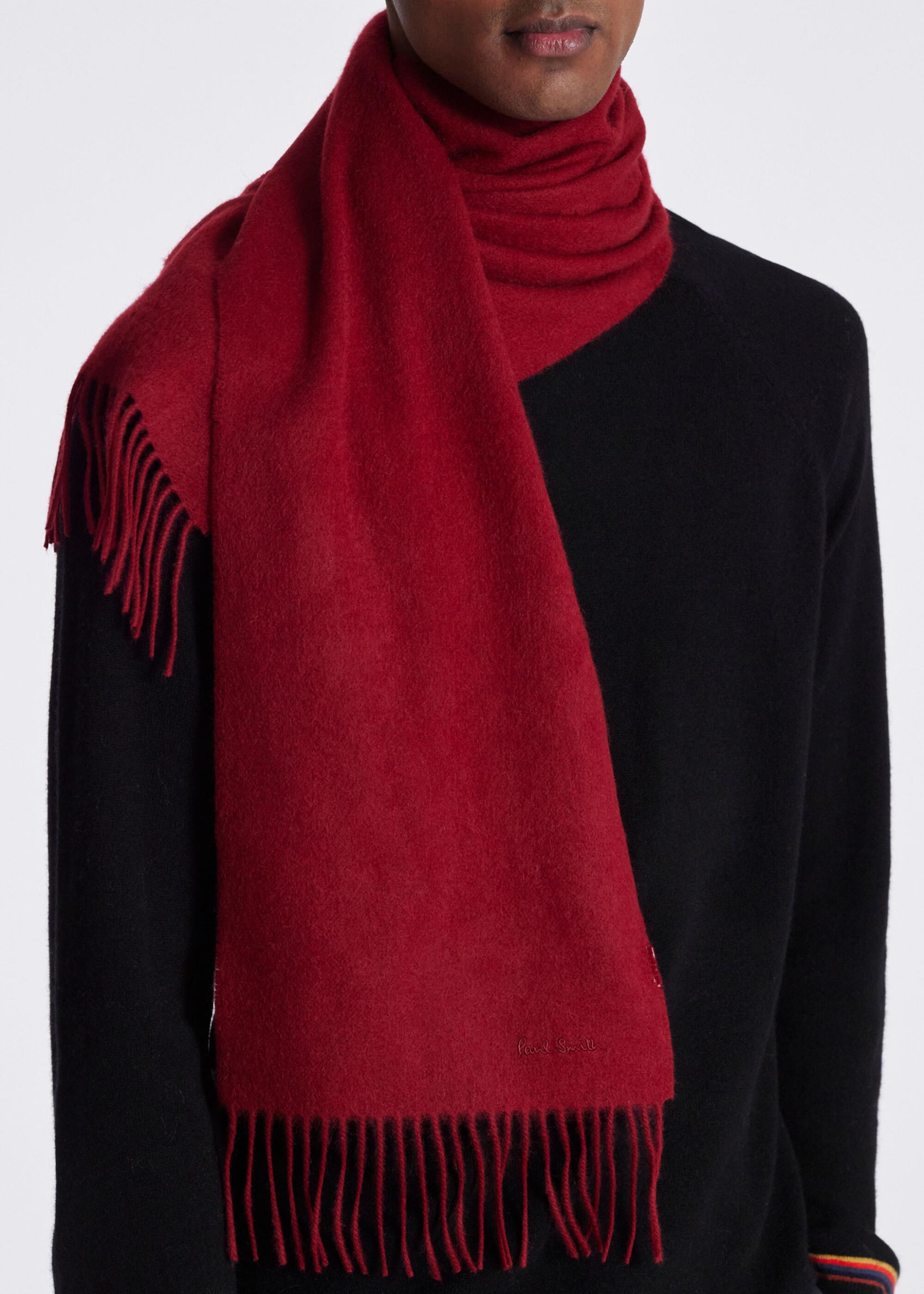 A red cashmere scarf wrapped around a man's neck. 