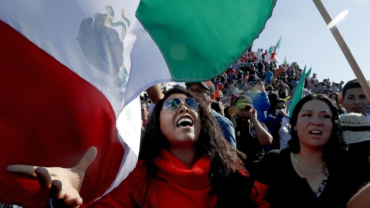 Hundreds of demonstrators march through downtown Tijuana on Sunday to protest the arrival of migrants from Central America.