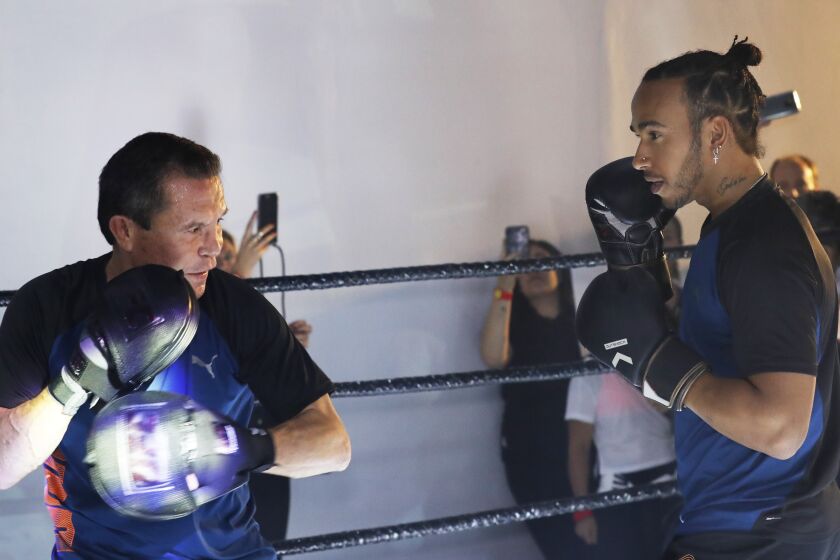 Mexican former boxing champion Julio Cesar Chavez, left, and British Mercedes driver Lewis Hamilton, spar during a promotional event ahead of the Formula One race in Mexico City, Wednesday, Oct. 23, 2019. Mexico Formula One Grand Prix will take place on Sunday, Oct. 27. (AP Photo/Marco Ugarte)