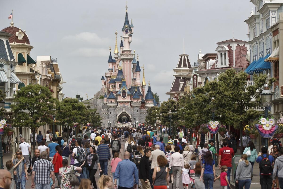 Visitors walk toward the Sleeping Beauty's Castle at Disneyland Paris.