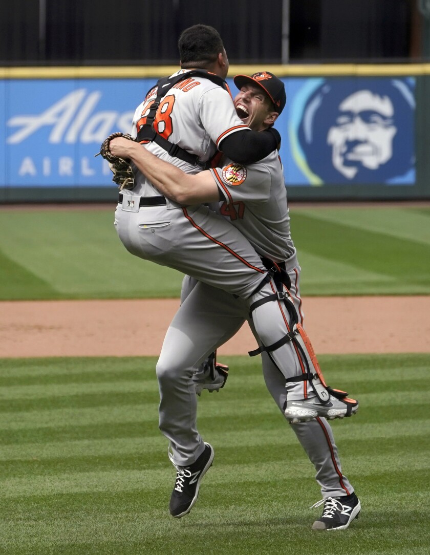 Baltimore Orioles starting pitcher John Means, right, celebrates with catcher Pedro Severino after Means threw a no-hitter baseball game against the Seattle Mariners, Wednesday, May 5, 2021, in Seattle. The Orioles won 6-0. (AP Photo/Ted S. Warren)
