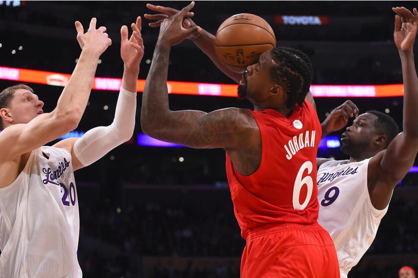Lakers center Timofey Mozgov (20) and forward Luol Deng battle Clippers center DeAndre Jordan for a rebound during during their Christmas evening game.