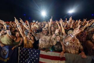 Indio, CA - April 27: Fans Daryl Clark, left center, of Joshua Tree, Cheyenne Thomas, right center, of Yucaipa, cheer as Jelly Roll performs on the Mane Stage on the first day of Stagecoach Country Music Festival at the Empire Polo Club in Indio Saturday, April 27, 2024. (Allen J. Schaben / Los Angeles Times)
