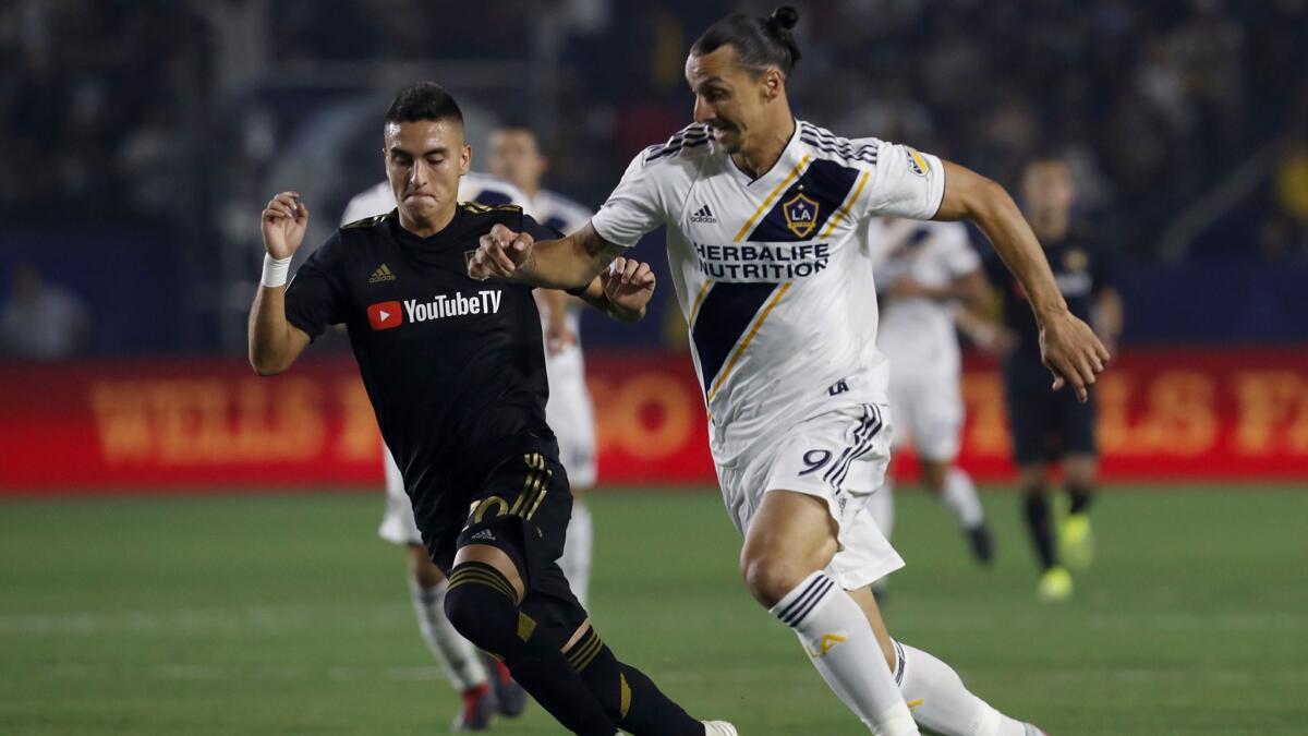 LAFC midfielder Eduard Atuesta battles for control of the ball against Galaxy forward Zlatan Ibrahimovic in the first half.