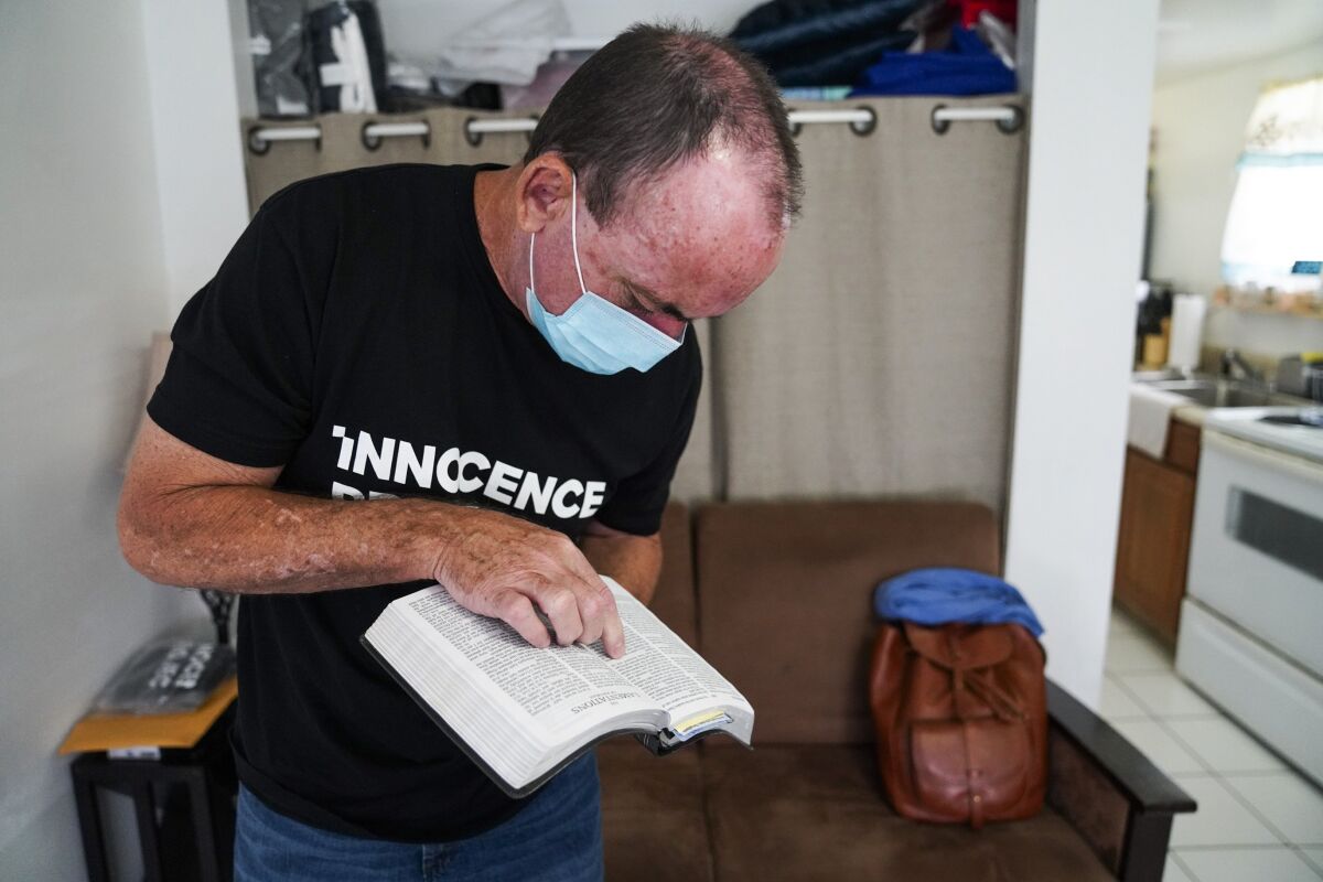 Robert Duboise looks up Jeremiah 52:31, a Bible verse he relates to, on Friday, Sept. 11, 2020 in Tampa. The Florida man who spent the last 37 years in prison on a rape and murder charge was freed from prison after officials discovered dramatic new evidence that proved his innocence. (Martha Asencio Rhine/Tampa Bay Times via AP)