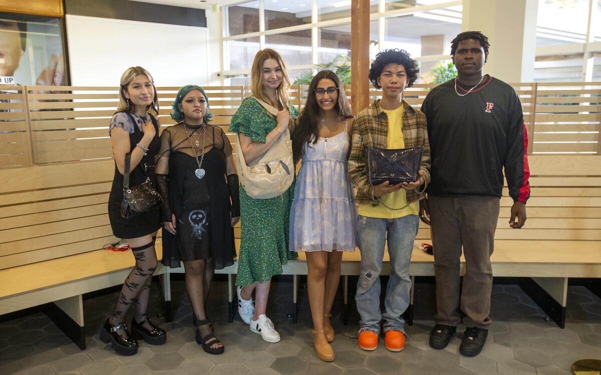 Teen fashion designers from Orange County schools pose with handbags they upcycled during a fashion show Thursday.