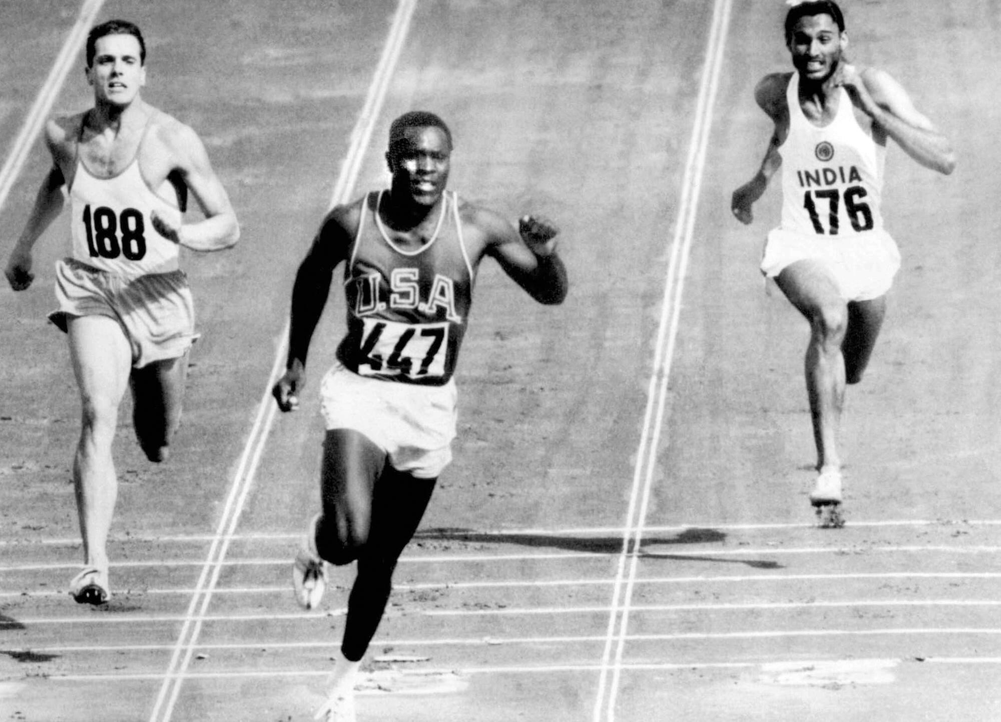 Rafer Johnson, center, finishes the fourth 100-meter heat of the decathlon at the Olympics in Rome on Sept. 5, 1960.