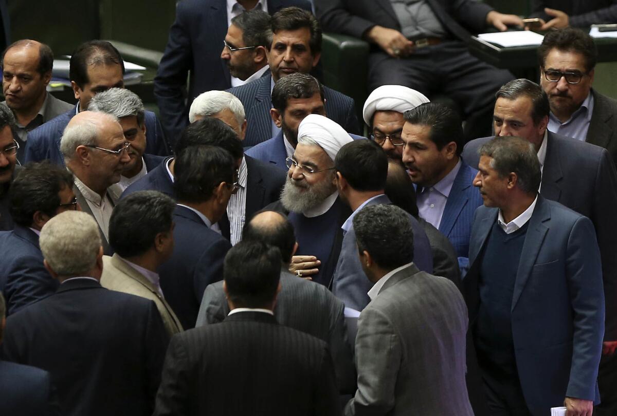 Iranian President Hassan Rouhani is surrounded by lawmakers after a speech in parliament on Sunday.