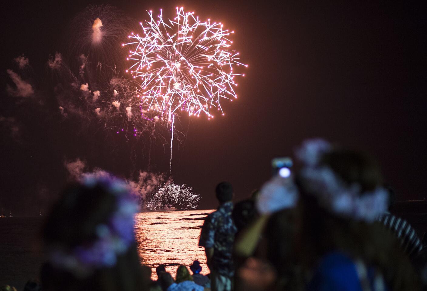 People watch a New Year's fireworks display on Waikiki beach. President Barack Obama, still on vacation in Hawaii, plans to spend New Year's Eve with loved ones "at home," the White House said.