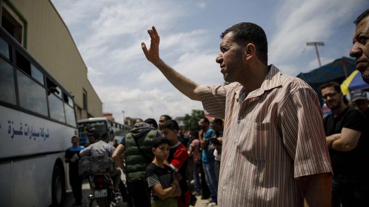 Emad Abu Safia waves goodbye to his children after they managed to board the bus to the Rafah border crossing in the Gaza Strip.