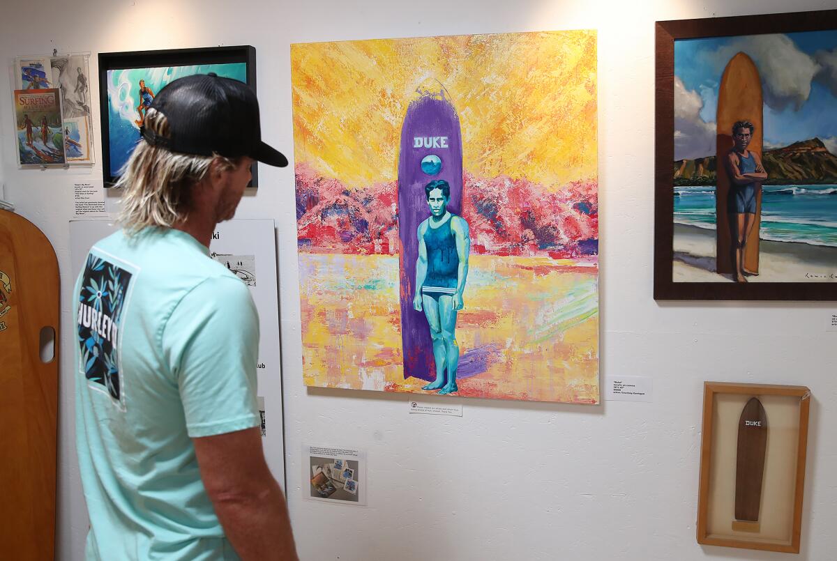 Brett Simpson looks over "Duke," a piece by fellow two-time U.S. Open of Surfing winner Courtney Conlogue, on Thursday.