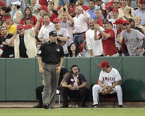 Umpire Doug Eddings who was involved in the controversial call gets it from the Angel fans as he umpires the right field line.