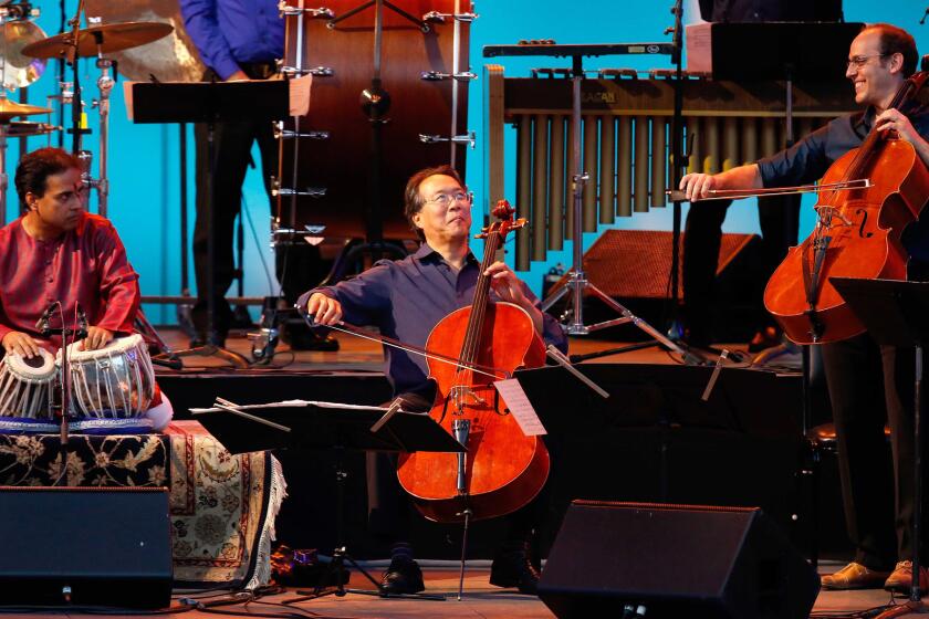 Yo-Yo Ma, flanked by Sandeep Das, left, and Mike Block, perform with other members of the Silk Road Ensemble on Sunday at the Hollywood Bowl.