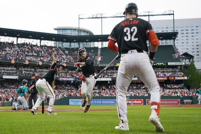 Baltimore Orioles' Gunnar Henderson, center, celebrates with Adley Rutschman, left, and Ryan O'Hearn (32) after hitting a home run against the Seattle Mariners during the first inning of a baseball game Friday, May 17, 2024, in Baltimore. (AP Photo/Jess Rapfogel)