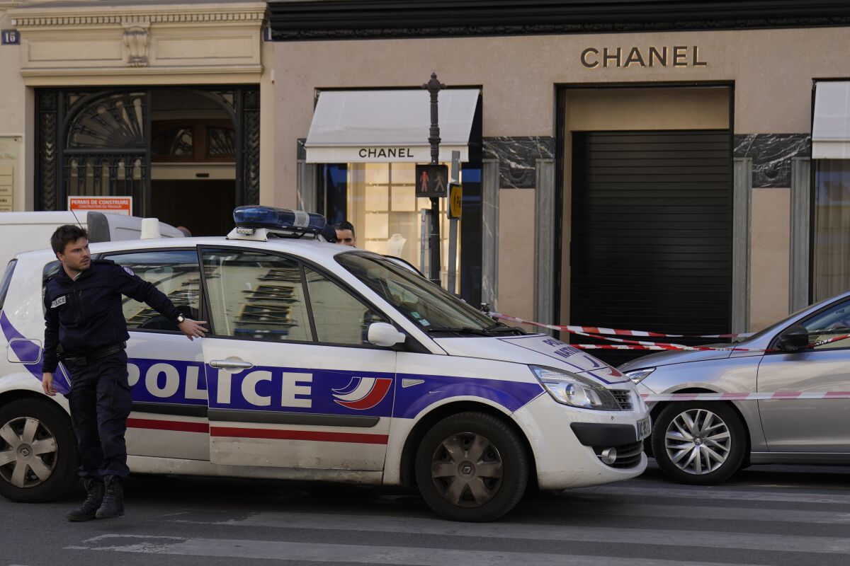 A police officer leaves his car after a hold-up in a Chanel boutique,Thursday, May 5, 2022 in Paris. No details were immediately available about what was stolen in the luxury fashion house shop by four helmeted persons who fled with a scooter and a motorcycle. (AP Photo/Francois Mori)