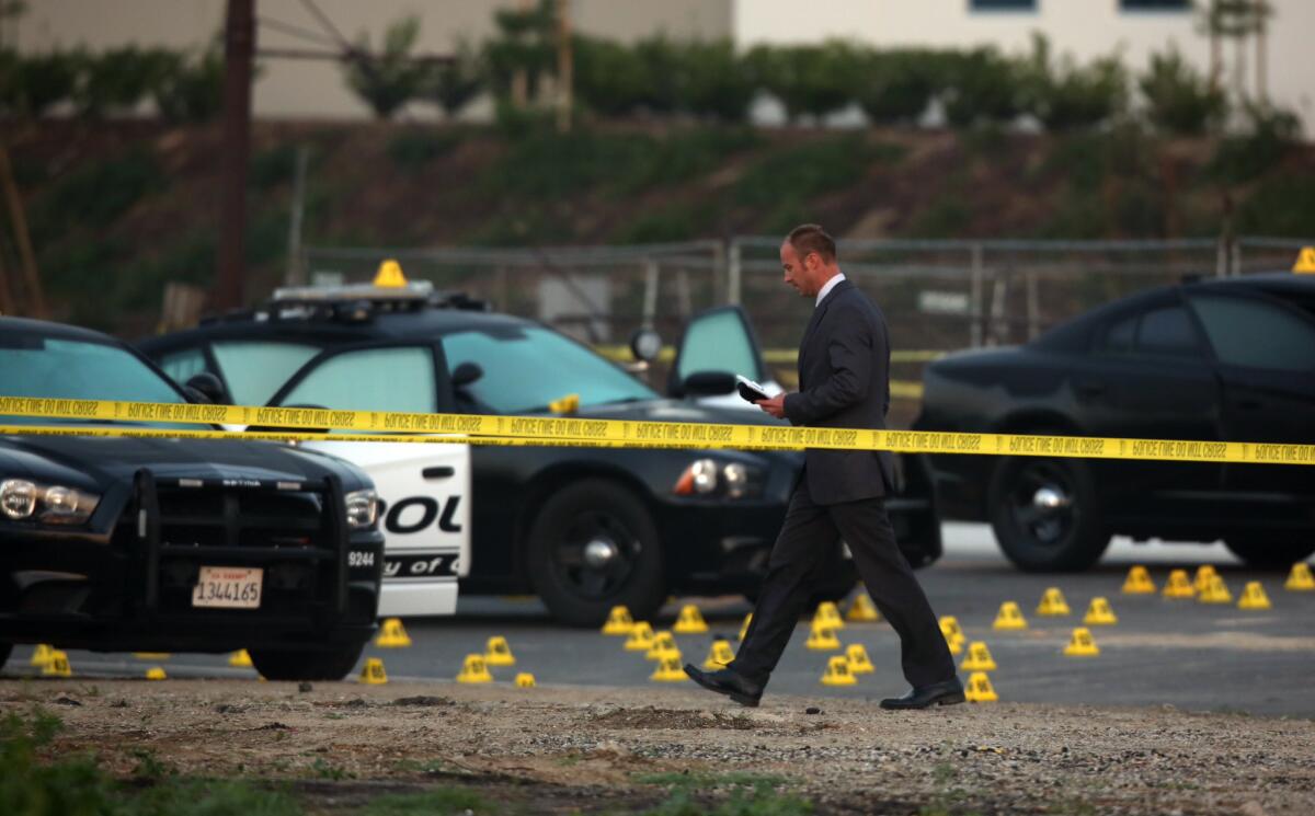 Evidence tags dot the area in Chino where a police chase ended with the fatal shooting of a man who was suspected of robbing a bank in Corona.
