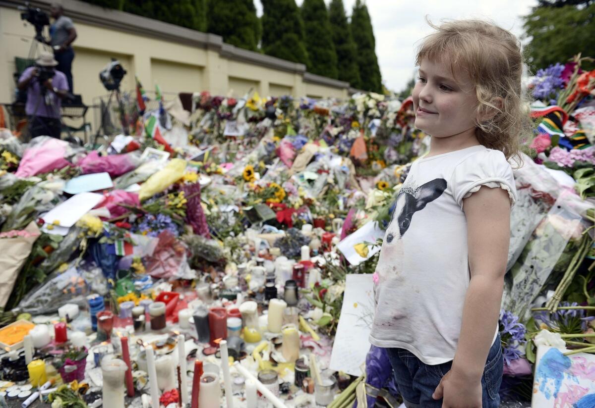 A child looks at flowers and tribute messages outside Nelson Mandela's home in Johannesburg, South Africa.