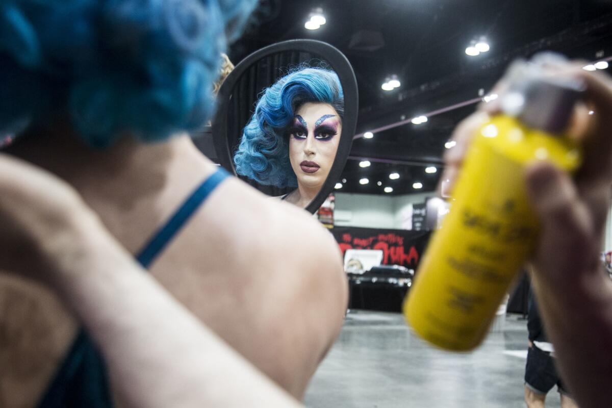 Lucy Lips, left, looks in the mirror for a touch-up before RuPaul's DragCon LA at Los Angeles Convention Center.