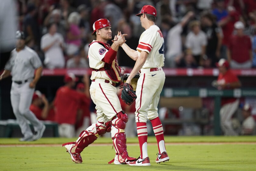 Angels reliever Jimmy Herget and catcher Max Stassi celebrate a win over the Yankees on Aug. 31, 2022. 