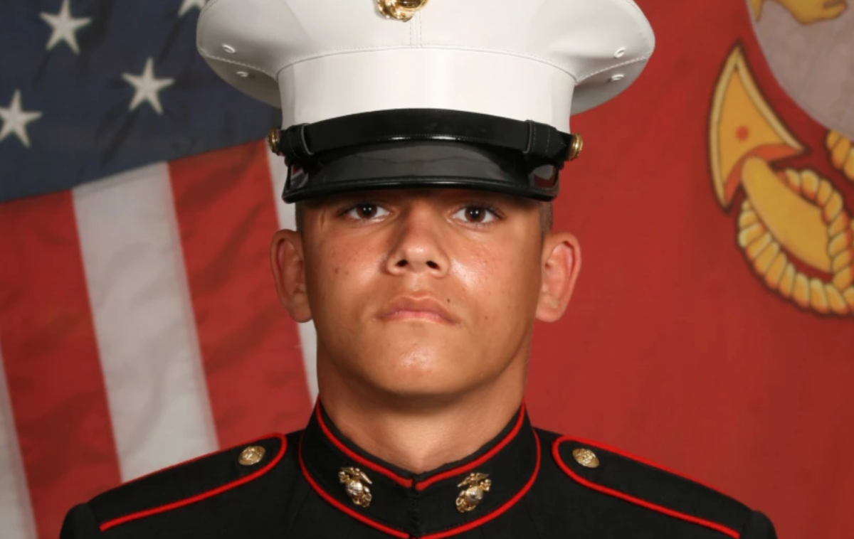 A U.S. Marine's bio picture in front of an American flag
