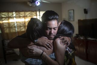 Marcos Marzo abraza a sus amigas que vinieron a despedirse de él, en La Habana, el miércoles 25 de enero de 2023, luego de enterarse que había recibido un permiso para viajar a Estados Unidos. (AP Foto/Ramon Espinosa)