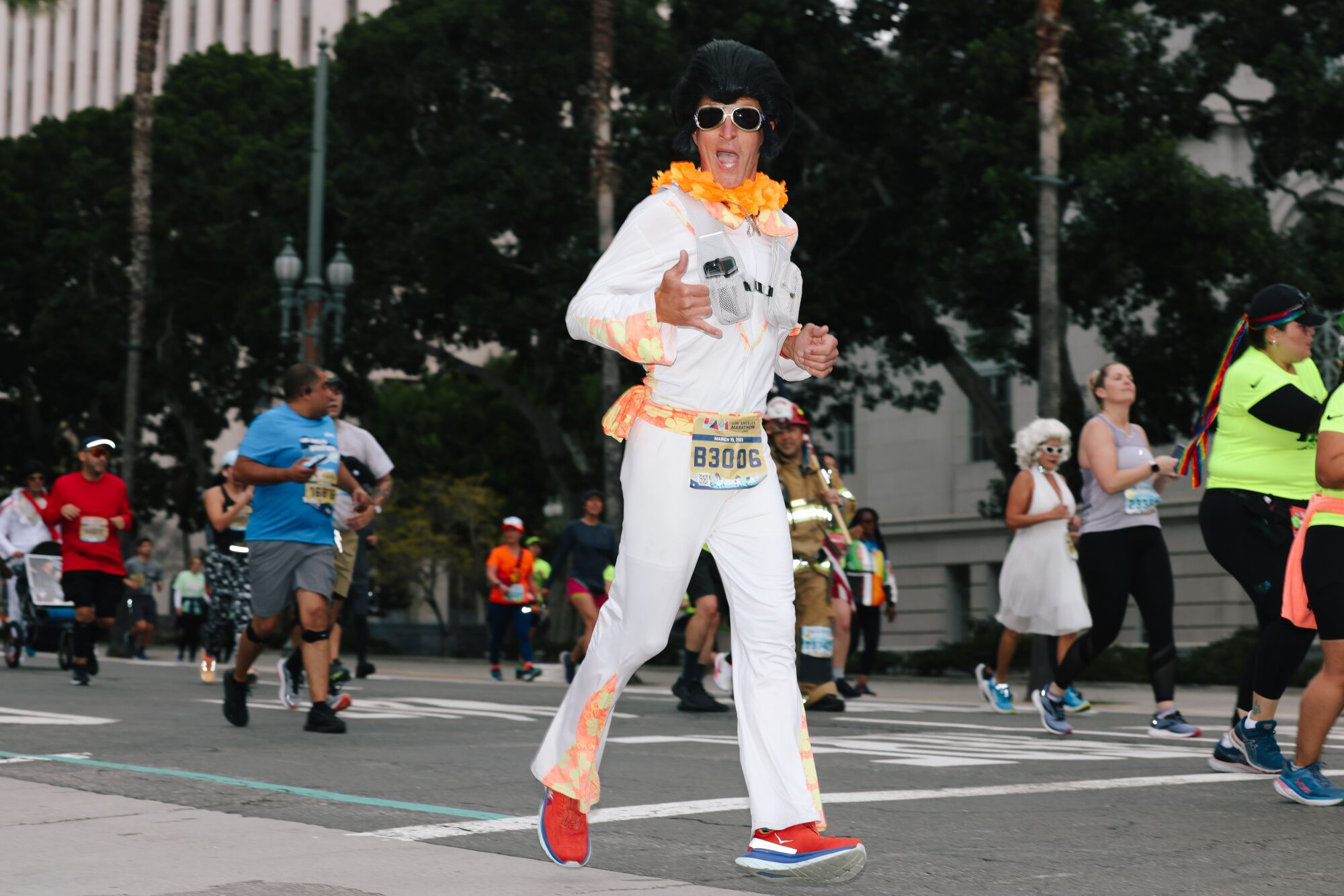 A runner dressed as Elvis passes City Hall.