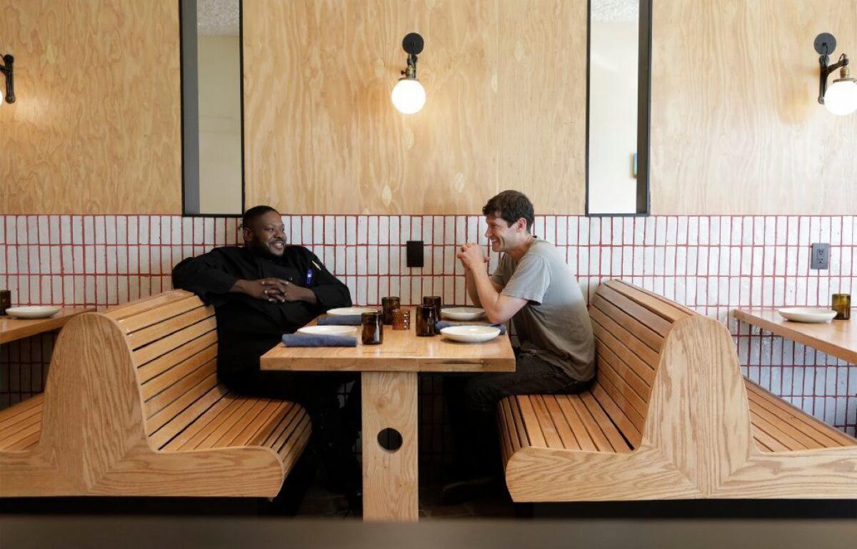 Chefs Keith Corbin, left, and Daniel Patterson sitting in one of the booths at Alta Adams.