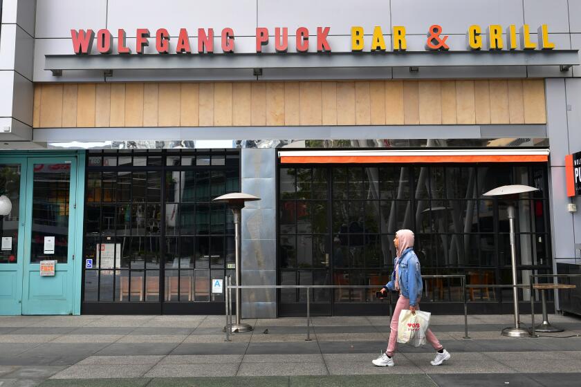 A pedestrian walks past a closed 'Wolfgang Puck Bar & Grill' restaurant in Los Angeles, California on March 17, 2020 as the coronavirus epidemic leads to restaurant and school closures as workers work from home in an effort to encourage social distancing. - The White House has suggested gatherings limited to 10 people or less as the number of coronavirus cases across the country passes 5,000 with 100 dead. (Photo by Frederic J. BROWN / AFP) (Photo by FREDERIC J. BROWN/AFP via Getty Images)