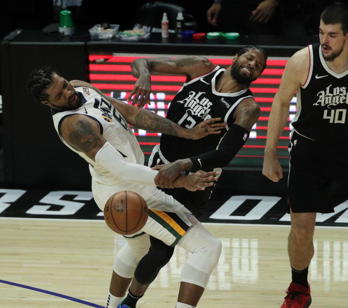 Clippers guard Paul George collides with Utah Jazz center Derrick Favors.