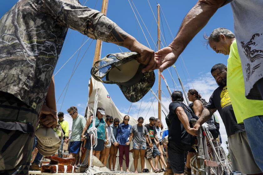 Maalaea, Maui, Monday, August 14, 2023 - A crew of Hawaiians join hands in prayer after delivering a boat load of supplies for Lahaina fire victims at Maalaea Harbor. (Robert Gauthier/Los Angeles Times)