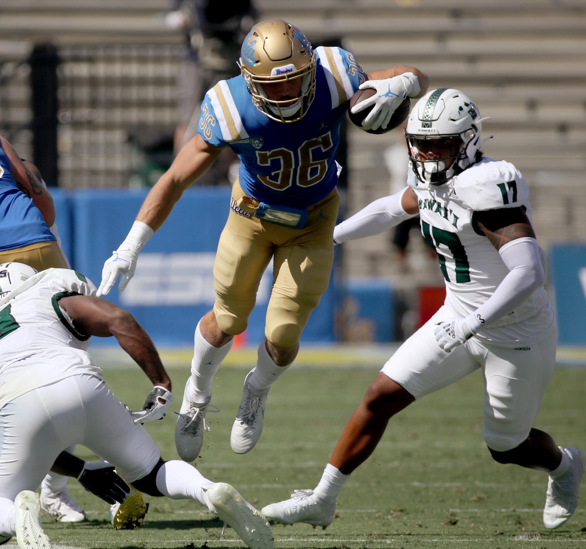 UCLA running back Ethan Femea fights for extra yards against Hawaii in the third quarter.