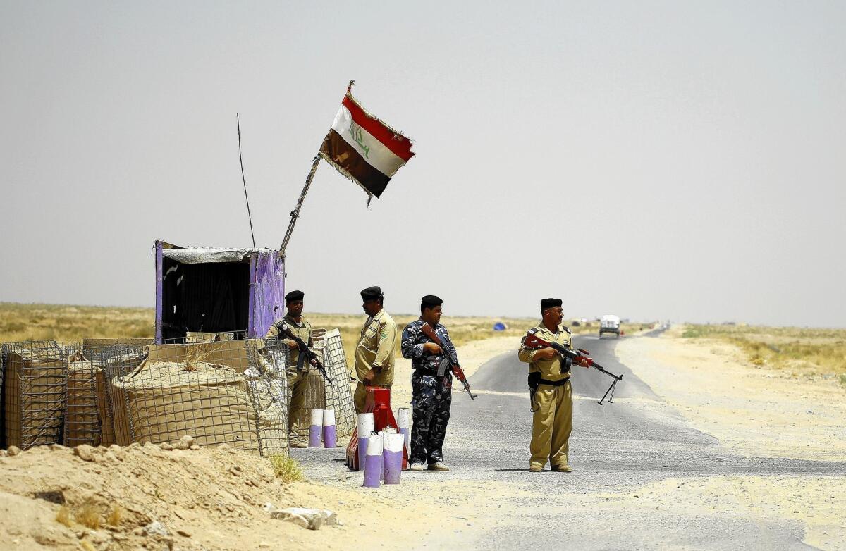 Iraqi Shiite Muslim fighters secure an area west of the holy city of Najaf. Shiite fighters have mobilized in support of government forces battling Sunni militants.