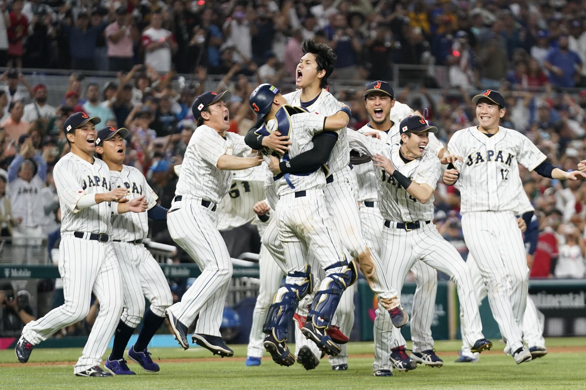 Shohei Ohtani (16) celebrates with his teammates after Japan defeated the U.S. in the WBC 