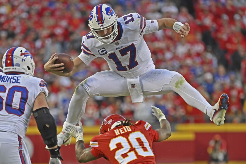 Buffalo Bills quarterback Josh Allen (17) hurdles Kansas City Chiefs safety Justin Reid.