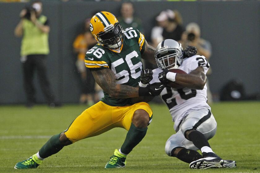 Oakland Raiders running back Darren McFadden is brought down by Green Bay Packers defensive end Julius Peppers during a game on Aug. 22.