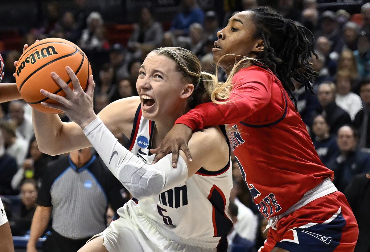 UConn guard Paige Bueckers, left, is fouled by Jackson State guard Miya Crump, right, in the first half of a first-round college basketball game in the NCAA Tournament, Saturday, March 23, 2024, in Storrs, Conn. (AP Photo/Jessica Hill)