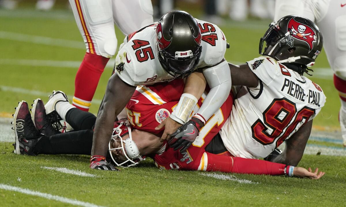 Kansas City Chiefs quarterback Patrick Mahomes is tackled by Tampa Bay's Devin White (45) and Jason Pierre-Paul.