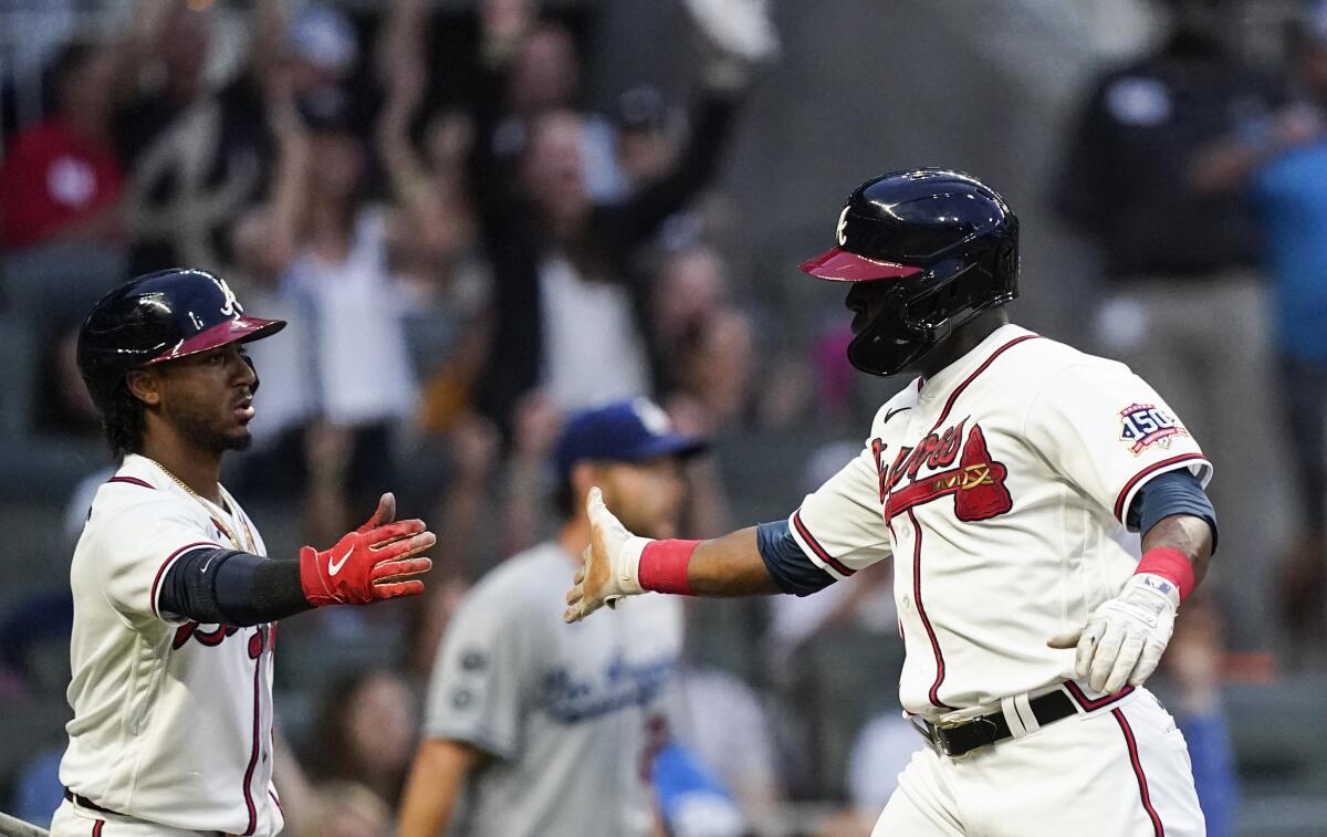 The Braves' Guillermo Heredia, right, celebrates with Ozzie Albies after scoring in the third inning June 5, 2021.