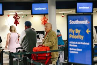 Los Angeles, CA - December 27: People inside the Southwest Airlines terminal area figure out their travel plans following an announcement to cancel all flights departing from Southern California until the end of the month at Hollywood Burbank Airport on Tuesday, Dec. 27, 2022 in Los Angeles, CA. (Dania Maxwell / Los Angeles Times)