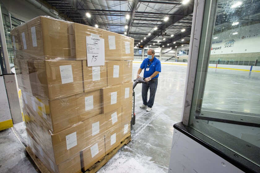 A pallet loaded with supplies is moved onto an Olympic-sized hockey rink at Great Park Ice in Irvine.