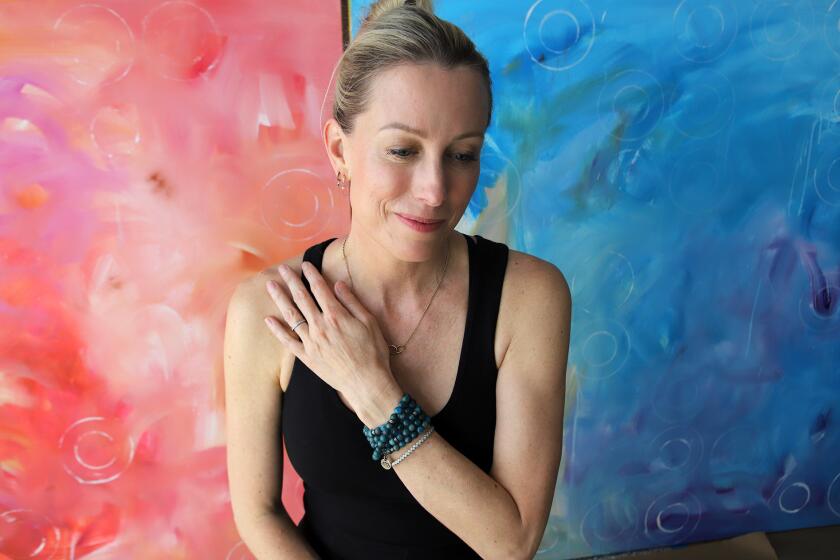 Artist Britt Michaelian a Reiki master poses for a picture in front of her paintings at her home in Newport Beach on Wednesday, May 1, 2024. Britt Michaelian work combines practices like reiki, quantum healing, sound bathes, as well as sacred rituals. (Photo by James Carbone)