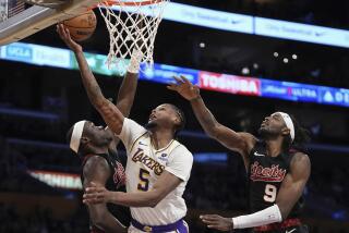 Los Angeles Lakers forward Cam Reddish, center, shoots as Portland Trail Blazers center Duop Reath, left and forward Jerami Grant defend during the first half of an NBA basketball game Sunday, Nov. 12, 2023, in Los Angeles. (AP Photo/Mark J. Terrill)