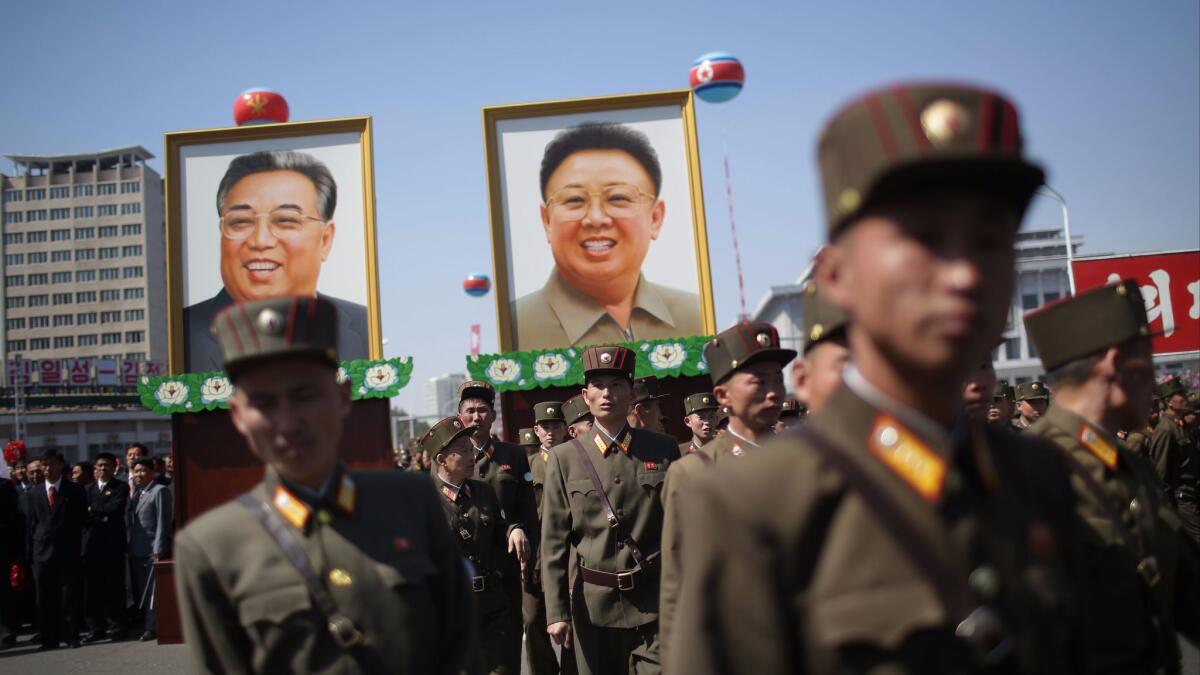 North Korean soldiers attend the opening of the Ryomyong residential area, while in the background, portraits of late North Korean leaders Kim Il Sung and Kim Jong Il are seen, on April 13, 2017, in Pyongyang, North Korea.