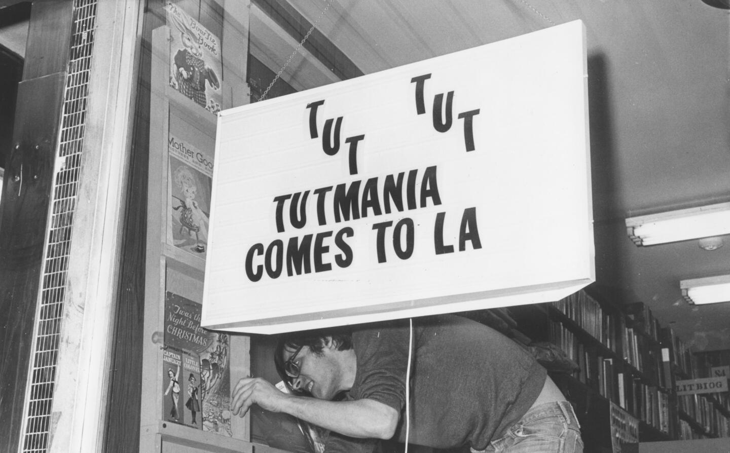 Cory Randall of Hollywood Book City puts finishing touches on his Tut windows sign on Jan. 29, 1978.