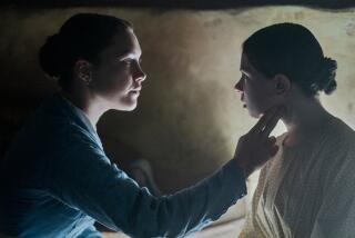 A woman strokes a young girl's face in "The Wonder," a movie set in 19th-century Ireland.