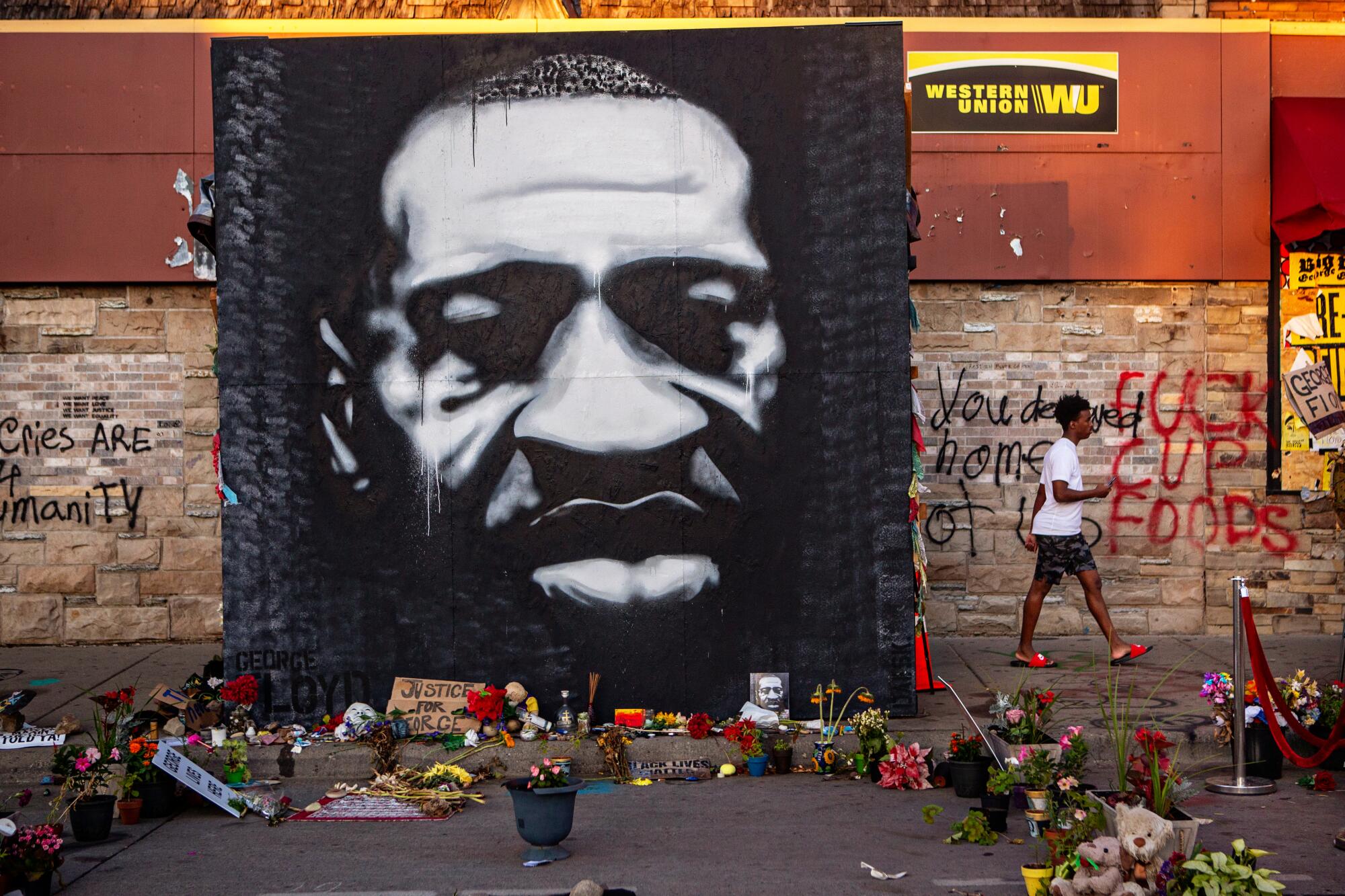 A mural of George Floyd stands on the sidewalk outside Cup Foods in South Minneapolis where he died while in police custody