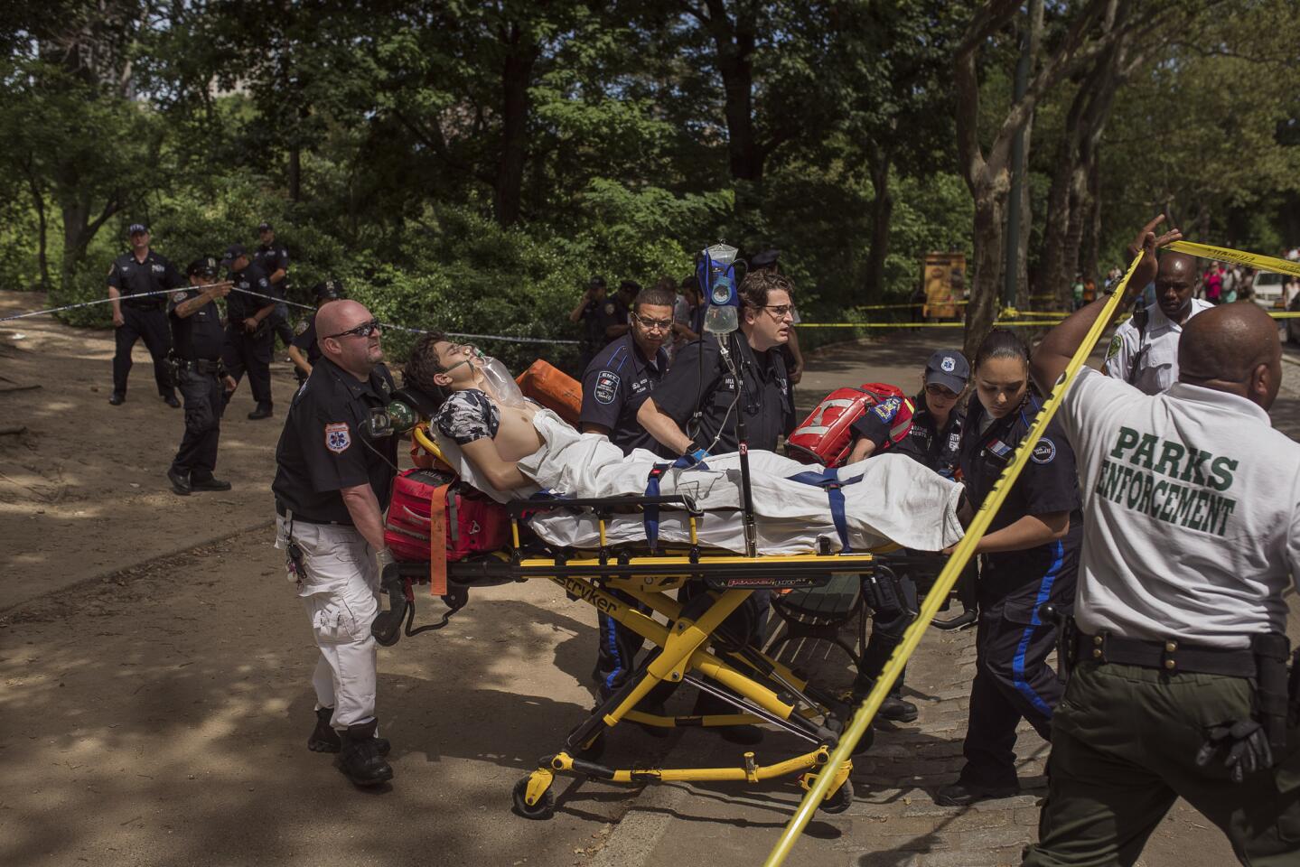A injured man is carried to an ambulance in Central Park in New York, Sunday, July 3, 2016. Authorities say a man was seriously hurt in Central Park and people near the area reported hearing some kind of explosion.