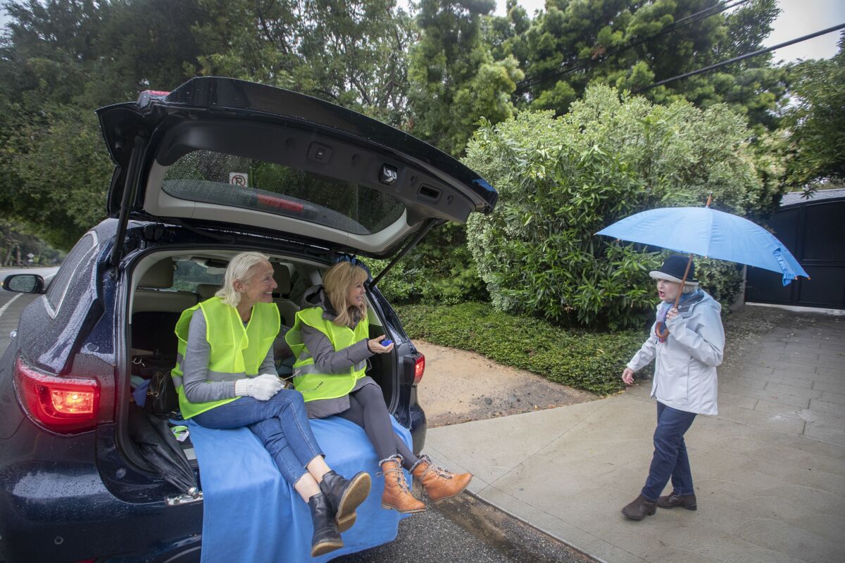 Mandeville Canyon homeowner association members Flo Chapgier, left, and Yolanda Bergman count the number of people evacuating while advising resident Laurie La Shelle during a recent wildfire drill.