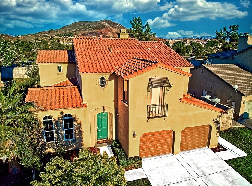 A brown home with a green door with mountain views in Winchester, California